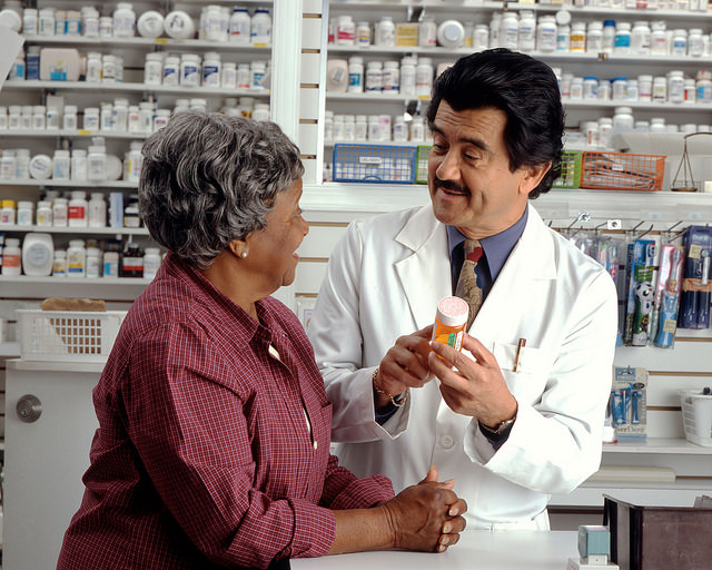 Pharmacien en train de délivrer des informations sur le traitement d'une patiente.