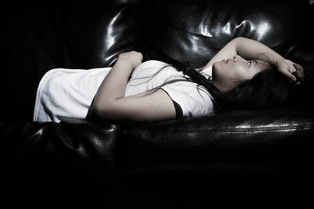 Jeune femme allongée sur un canapé.