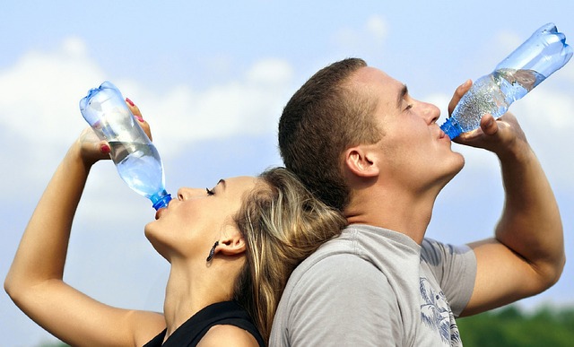 Photographie d'une femme et d'un homme en train de s'hydrater en buvant de l'eau.